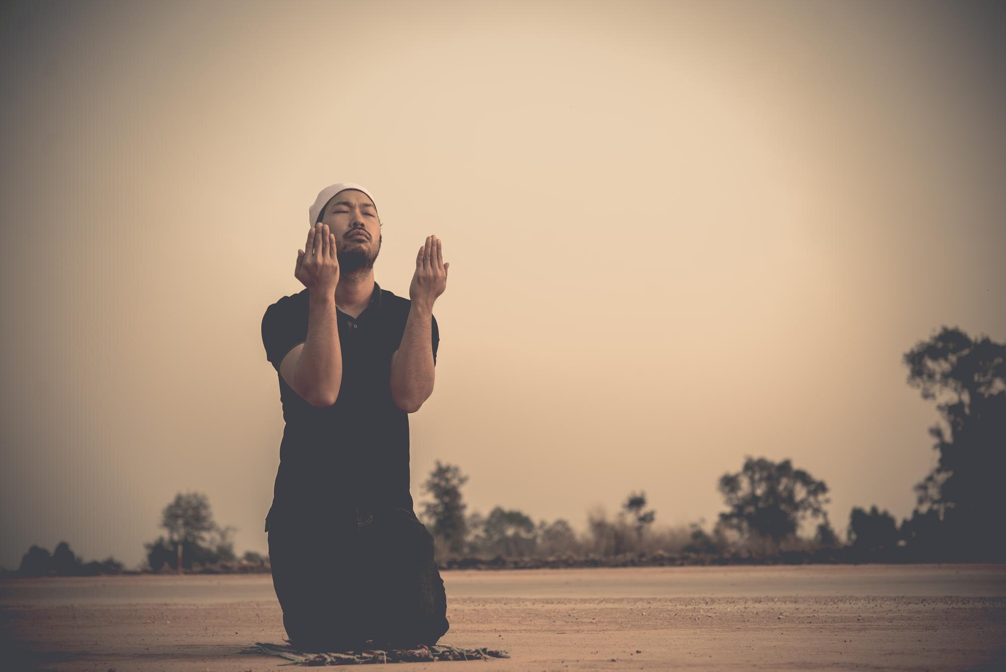 Man praying at sunset
